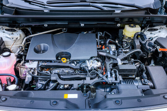 Modern hybrid vehicle engine compartment with detailed components and wiring. High resolution shot of automotive engineering and mechanical power unit.
