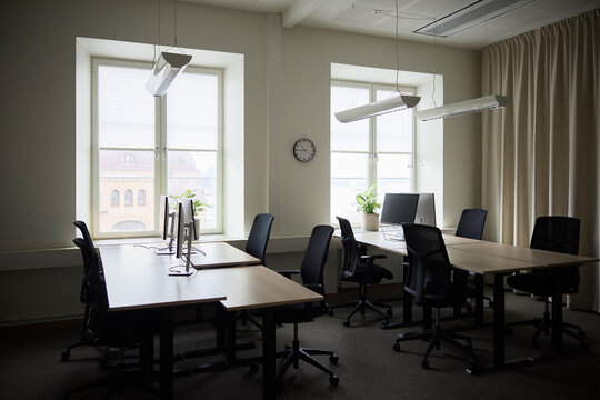 Empty desks with computers and chairs in tech office