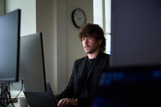 Focused male creative professional working on technologies in tech office