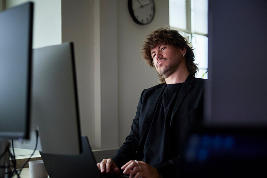Male tech professional working on computers in office