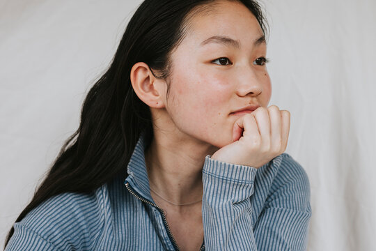 Contemplative young woman looking away while leaning on elbow