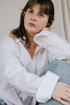 Thoughtful young woman wearing white shirt looking away
