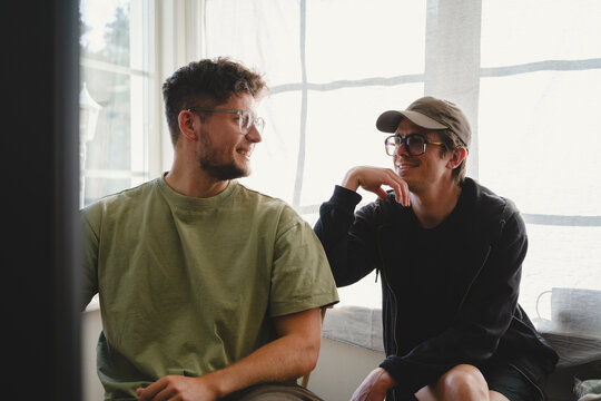 Smiling male friends spending leisure time with each other at home