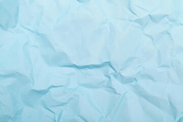 Fototapeta premium A blank sheet of crumpled blue paper features a rough creased texture and wrinkled grunge pattern across its damaged surface to create a unique old material backdrop for design art