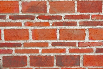 Naklejka premium Detailed red brick wall with slightly varied tones and natural imperfections. Authentic masonry texture suitable for backgrounds, architectural concepts, and industrial design use.