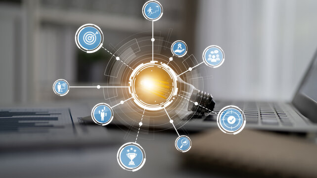 A modern workspace featuring a laptop and a light bulb surrounded by digital icons. This image symbolizes innovation, productivity, and strategic growth in business. Crux