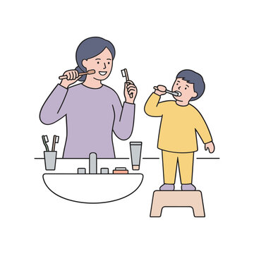A mother and son brush their teeth together at a bathroom sink.