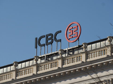ICBC bank logo and red emblem mounted on a classic building rooftop in Warsaw