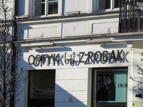 View of Optyk Z. Robak and Dior signs on a historic building