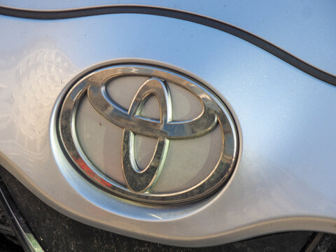 Detailed view of a silver Toyota logo on a metallic car body