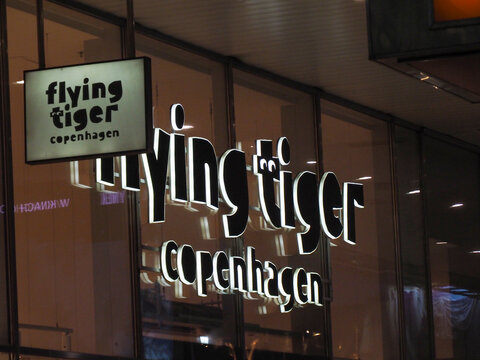 Close up of the Flying Tiger Copenhagen neon logo on a glass shop window