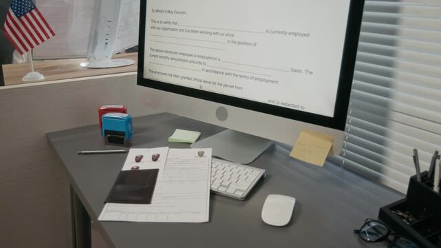 Medium shot of computer with digital certificate of employment form, application, passport and photos of mature black male customer on desk of visa officer at foreign embassy