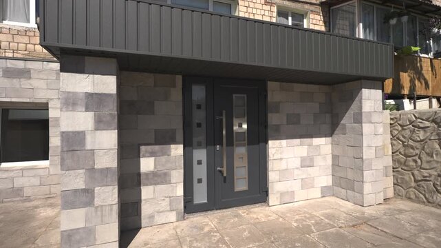 
Residential building with stone facade and modern entrance, urban real estate exterior concept.