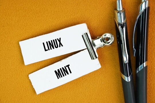 Pen and paper with the word linux mint. open-source operating system designed for desktops and laptops, based on Ubuntu and Debian.