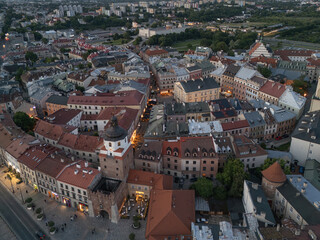 Stare Miasto w Lublinie nocą z oświetlonymi ulicami, Zamkiem i Wieżą Trynitarską, widok z drona © Karol
