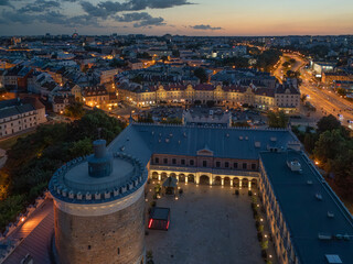 Stare Miasto w Lublinie nocą z oświetlonymi ulicami, Zamkiem i Wieżą Trynitarską, widok z drona © Karol