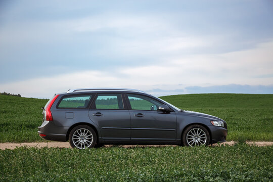 MINSK, Belarus - May 1, 2015. Side view of a Volvo v 50 car on a dirt road against the background of a green field. A Swedish car