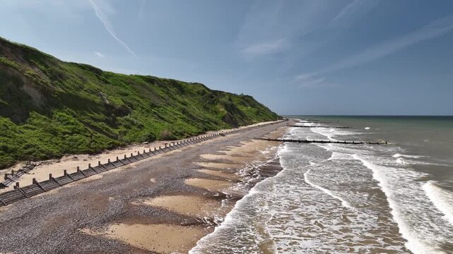 Close Aerial View of Waves Washing Over Sandy Beach and Groynes at Mundesley Norfolk Coast