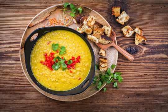 Traditional Indian style dal lentil soup dal tadka with roasted flatbread served as top view in a design pot