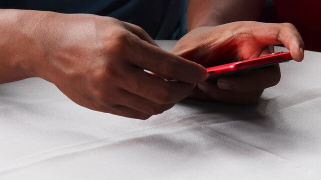 Close-up of male hands inserting, removing and replacing sim card from mobile phone, demonstrating process of changing cellular provider or managing mobile data.