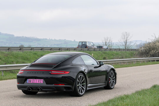 Nancy, France - March 22nd 2026 : View on a black Porsche 991 Carrera 4S driving on a street. This is the 991.2 version of the 911 Carrera 4S powered by a Flat-6 engine.