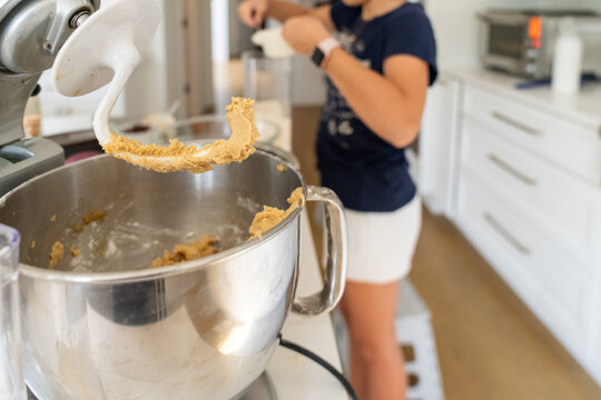 Teenager using stand mixer to prepare brownie batter in home kitchen