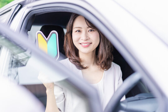 初心者マークを持った若い女性ドライバー