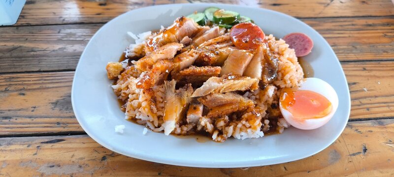 A plate of Khao Moo Daeng  a popular Thai street food dish of rice topped with various types of pork