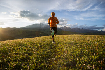 Trail runner running on the high altitude grassland mountain top trail © lzf