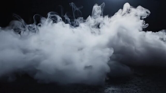 Smoke flows along the ground in an empty dark space with a faint light above at night