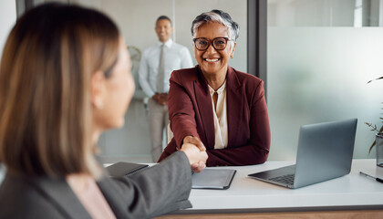 Fototapeta premium Businesswomen shaking hands in office meeting