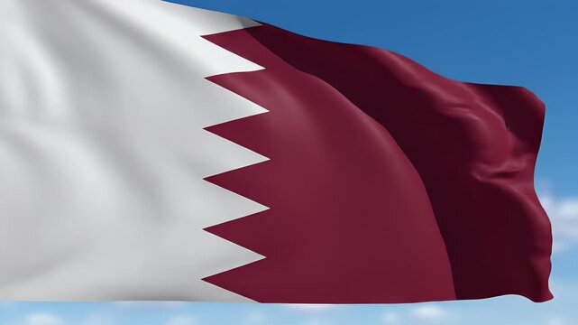 A close-up of a maroon and white wavy flag against a bright blue sky with clouds