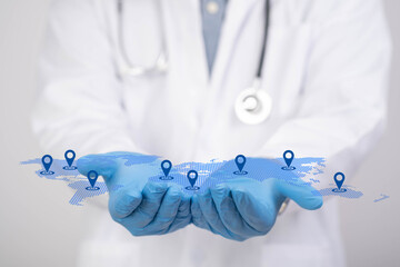 Doctor holding digital world map with location pins representing global healthcare network, telemedicine services, international medical access and connected hospital technology worldwide. © Bordinthorn