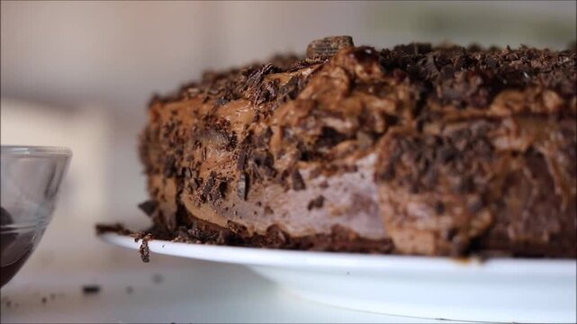 Delicious homemade chocolate cake with creamy frosting and cherries on the side