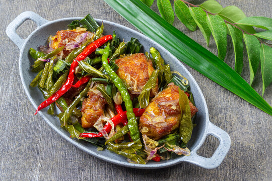 Ayam Tangkap,typical Aceh Indonesia culinary delights, Fried chicken cut into small pieces, cooked with rich spices, and served covered with curry leaves (temurui), pandan leaves, and green chilies on