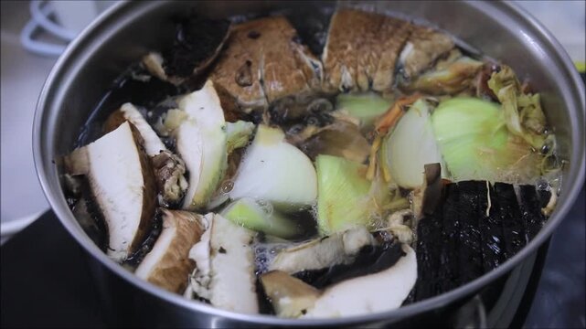 Simmering portobello mushrooms and onions in a pot for a rich broth