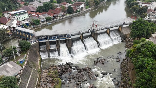 An aerial drone perspective reveals the historic Katulampa Dam spanning the Ciliwung River in Bogor