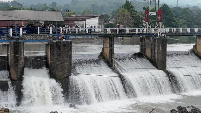 An aerial drone perspective reveals the historic Katulampa Dam spanning the Ciliwung River in Bogor