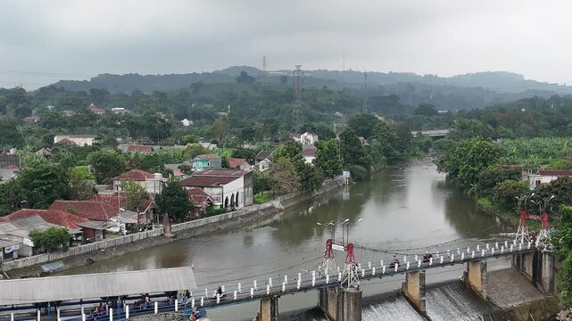 An aerial drone perspective reveals the historic Katulampa Dam spanning the Ciliwung River in Bogor