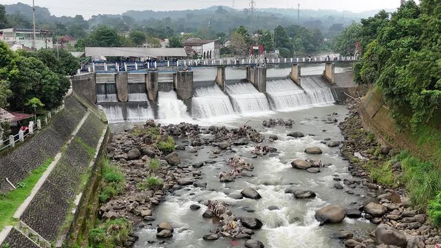 An aerial drone perspective reveals the historic Katulampa Dam spanning the Ciliwung River in Bogor