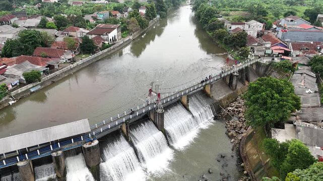 An aerial drone perspective reveals the historic Katulampa Dam spanning the Ciliwung River in Bogor