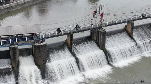 An aerial drone perspective reveals the historic Katulampa Dam spanning the Ciliwung River in Bogor