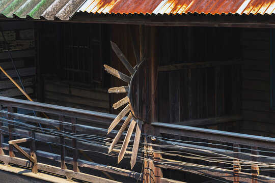 Old traditional wooden house balcony featuring unique sunburst wood carving decoration and designed to prevent people from climbing over balcony. Sunburst design by wood craft. Traditional lifestyle