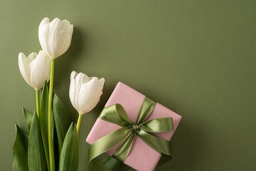 Fototapeta premium Elegant pink gift with green satin bow and fresh white tulips arranged on olive background for Happy Mother's Day greeting and springtime gratitude