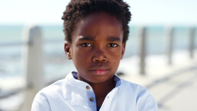 Arms crossed, face and tantrum with black kid on promenade for holiday, travel or vacation. Beach, frustration and miserable with unhappy African child outdoor on boardwalk for emotional reaction