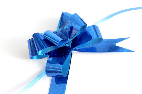 On a white background lies a blue paper bow for wrapping a gift.