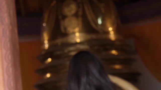 6.12.2025 Sri Lanka. Female tourist offering lotus flower to Buddha statue inside a colorful stupa temple in Matara, Sri Lanka.