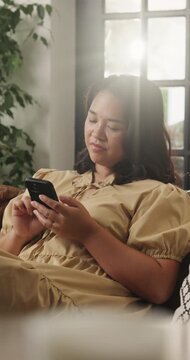 Thinking, woman and relax with smartphone in lounge, online or communication with contact on website. Typing, flare and person with mobile for chat, reflection and scroll message with tech in home