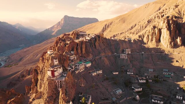 4K Aerial view of mesmerising Dhankar monastery during sunset in Spiti Valley, Himachal Pradesh, India. Ancient Buddhist monastery on cliff and river streams in mountain valley. Travel and holiday con