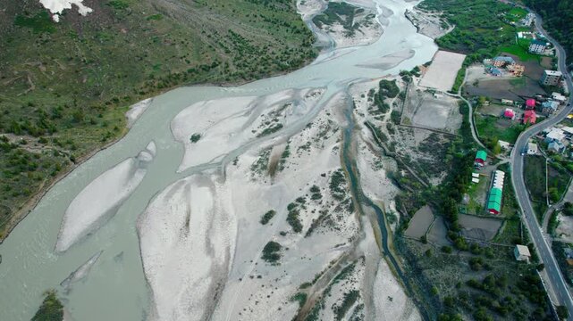 4K aerial view of water streams in river bad and mountain landscape. River flowing besides road in Jispa village at Lahaul, Himachal Pradesh, India. Travel India.